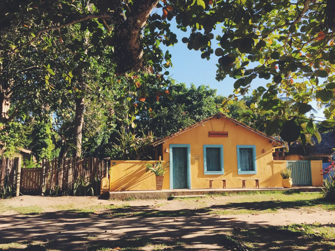 Casa amarela de praia sob as árvores