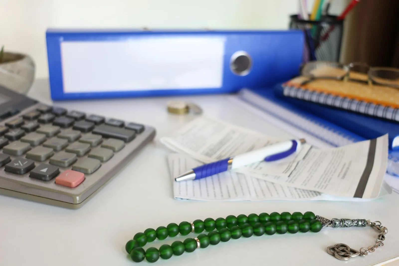 Calculadora, papéis e pastas sobre a mesa